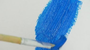 Güzel mavi renk ile boyama bir boya sanatçı boya fırça yukarıya kapatmak