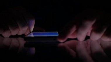 Adam masada karanlıkta Smartphone Internet sayfalarının gözatma