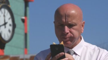 Aç işadamı cep telefonu Online haber okumak ve bir aperatif yemek