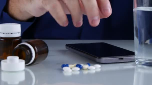 Uomo Irrequieto Gioca Con Cellulare Sul Tavolo Cerca Alcune Pillole — Video Stock