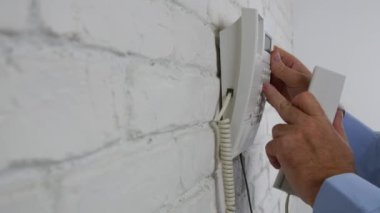 Ofiste iş adamı duvara sabit bir telefonu kullanarak telefon çağrısı yapma