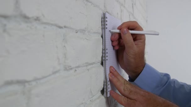ビジネスマンの仕事がオフィス内の壁に議題とペンを使用してノートを取る — ストック動画