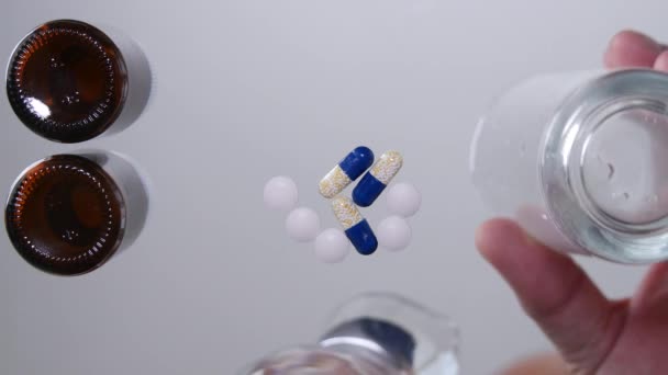 透明テーブル錠剤と水とガラスを充填人手を介して撮影 — ストック動画