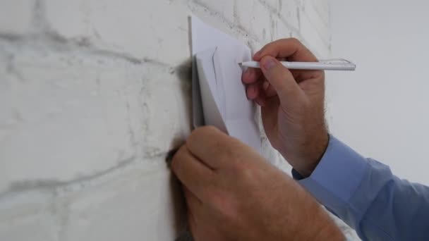 ビジネスマンは オフィスの壁に紙の部分に通知を書く — ストック動画