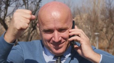 Ağır çekim ile cep telefonunuza konuşan adam Thumbs Up ve zafer el hareketleri yapmak