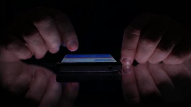 Görüntü Smartphone Online başvuru karanlıkta kullanarak adam elleriyle kapatın