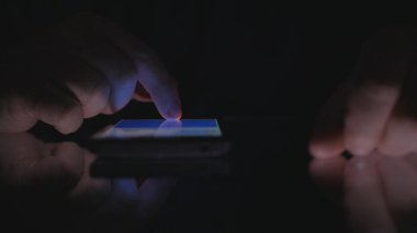 Olgun adam ellerini bir Smartphone kullanarak karanlık Office metin tablo