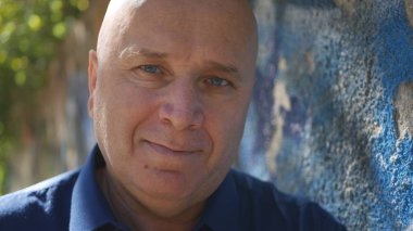 Kameraya bakarak ve memnun gülümseyerek mutlu bir insan