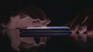 Olgun adam ellerini bir Smartphone kullanarak karanlık Office metin tablo