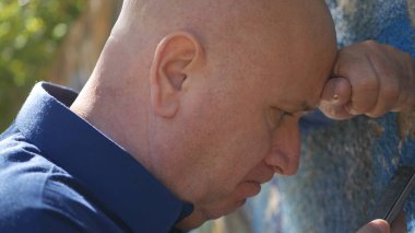 Adam kalın kafa duvar ve oku cep telefonu mesajları ile üzgün