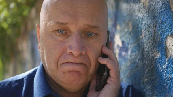 Upset Man Looking Disappointed Talking to Cellphone on the Street