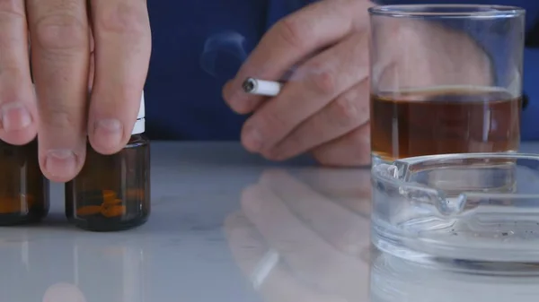 Человек Столе Выберите Медицинские Таблетки Пить Алкоголь Курить Сигарету Лицензионные Стоковые Фото