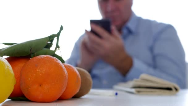 Zrelaksowany Człowiek Tekstu Przy Użyciu Telefonu Komórkowego Gazety Świeże Owoce — Wideo stockowe