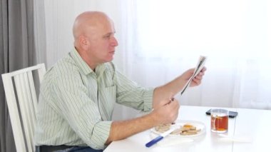 Gazete okuma ve ev mutfak içinde kahvaltı rahat işadamı