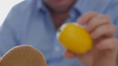 Elinde meyve tutmak isteyen adam ve bir limon ve bir kivi analiz