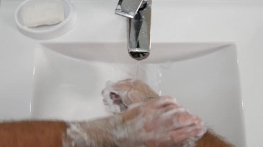 Sabun ve su ile yıkama banyo adam olun beyaz köpük ellerinin üstünde
