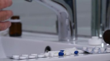 Bir tıbbi yapma adam tedavi olarak bir banyo lavabo cam su koy