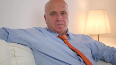 Bıkkın ve tembel bir işadamı bir kanepede rahatlatıcı evde oturan yorgun