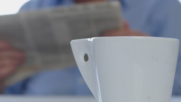 Расслабленный Бизнесмен Прочитайте Газетную Страницу Выпейте Чашку Горячего Кофе — стоковое видео