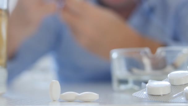 Malade prenant des pilules et des drogues avec de l'alcool et des cigarettes 