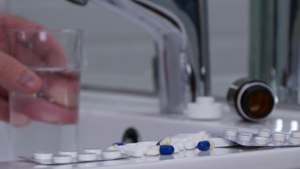 多くの医療薬と一緒に飲むガラスの水を取る男 — ストック動画