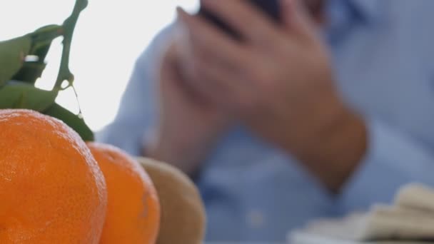 Cep Telefonu Kullanarak Tablo Metin Üzerinde Taze Meyve Ile Işadamı — Stok video
