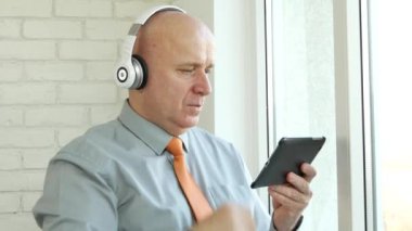 Man tablet ve kulaklıklar ile müzik dinleyin ve el Watch saati kontrol