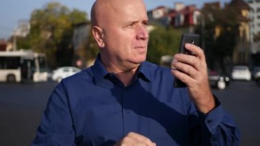 Adam görüntü bir Cellphone metin okuma ve sokak etrafında hayal kırıklığına bakıyordu