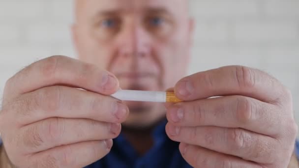 Imagen del hombre rompiendo un cigarrillo con las manos en una campaña contra el tabaco — Vídeos de Stock