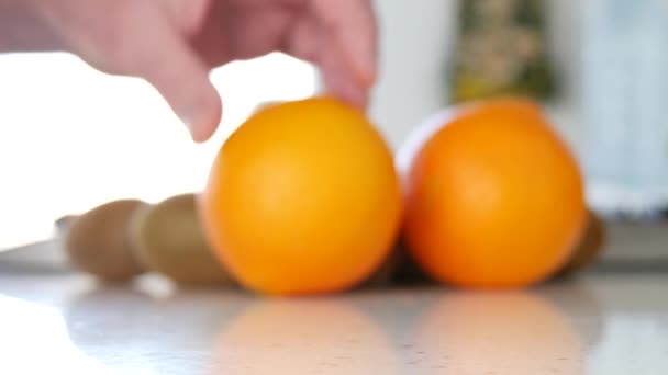 Uomo mano presentando una dolce succosa e di buona qualità frutta arancione sulla tavola — Video Stock