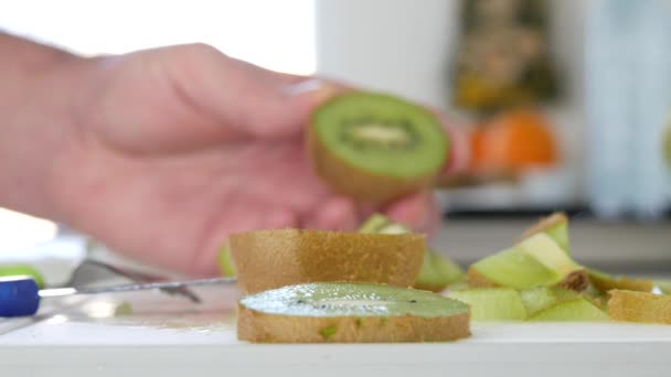 Hände in Großaufnahme in der Küche präsentieren eine Scheibe frischer und süßer Kiwi-Früchte — Stockvideo