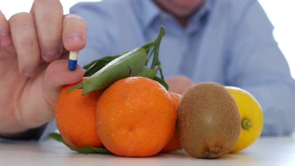 El médico compara el consumo de frutas con el abuso de medicamentos que muestran píldoras de vitaminas coloreadas — Vídeos de Stock