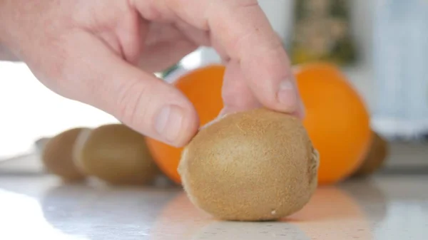 Bild med man hand på kök presentera en fräsch och välsmakande Kiwi frukt — Stockfoto