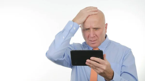 Empresario molesto leyendo malas noticias asombradas en la tableta y gestos nerviosos —  Fotos de Stock