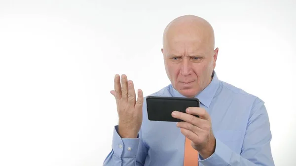 Изображение с озлобленным бизнесменом, читающим удивительные финансовые плохие новости на мобильном телефоне Стоковое Изображение
