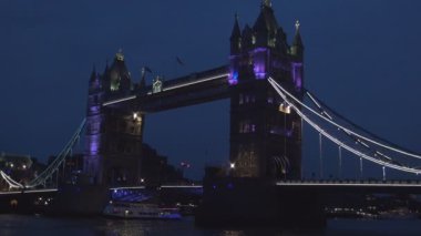 Thames Nehri üzerinde Kule Köprüsü ve tekne trafiği ile Londra şehir merkezi gece görünümü