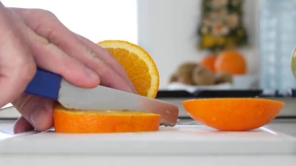 Uomo in cucina tagliato per insalata Frutta all'arancia a fette fresche dolci e aromatizzate — Video Stock