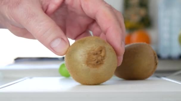 Mann präsentiert eine süße saftige und qualitativ hochwertige Kiwi-Frucht auf dem Tisch — Stockvideo