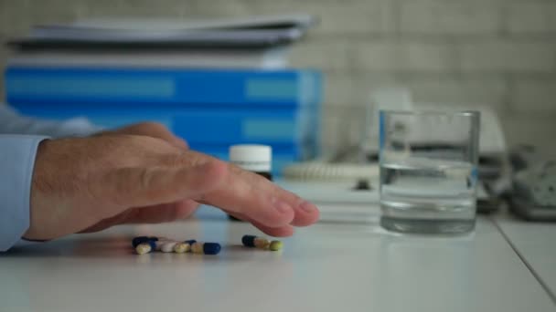 Homem na sala de escritório sofrendo de uma grande dor de cabeça Selecionando alguns comprimidos médicos coloridos — Vídeo de Stock