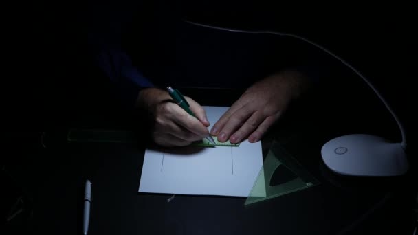 Karanlık ofiste geç saatlere kadar çalışan iş adamı teknik plan için çizim araçlarını kullanma — Stok video