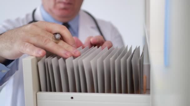 Médico poner de nuevo en el archivo del hospital un historial médico y cerrar el cajón — Vídeos de Stock