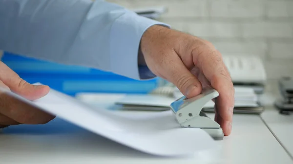 Empresario en Oficina Archivando Documentos con un Perforador de Agujeros de Papel —  Fotos de Stock