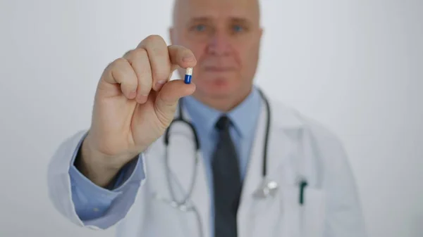Selbstbewusster Arzt empfiehlt Vitaminkur und zeigt in der Hand eine medizinische Kapsel — Stockfoto