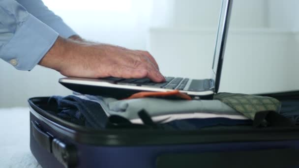 经理在酒店房间准备旅行手提箱与衣服和工作在笔记本电脑 — 图库视频影像