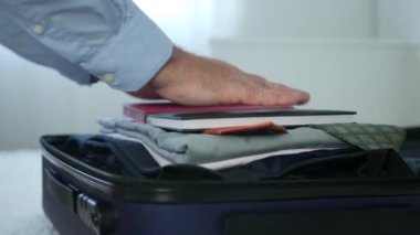 Otel odasında işadamı bir bavul temiz giysiler ve bir gündem koymak