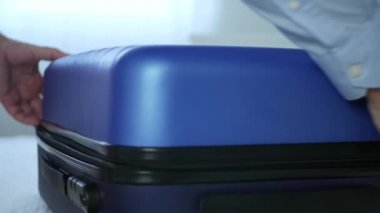 İş adamı otel odası açık bavul ve elbiselerini ve bir kitap dışarı atın