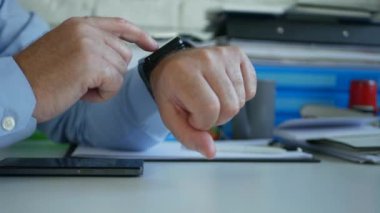 Ofis meşgul Işadamı onun SmartWatch kullanarak kontrol zamanı ve mesajlar