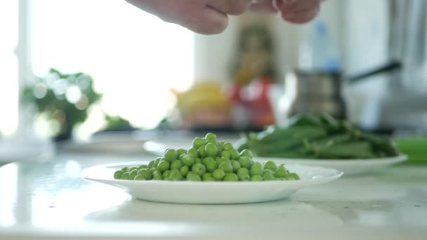 Hombre en la cocina Seleccione y limpie guisantes verdes frescos para cocinar — Vídeo de stock