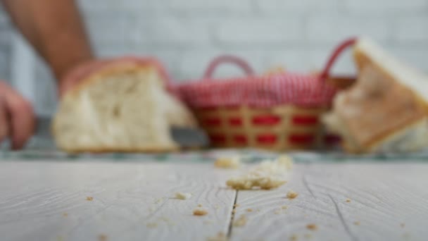 Imagen con migas sobre la mesa y pan fresco cortado en rodajas en segundo plano — Vídeo de stock