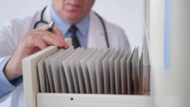 医生在医院档案文件和医疗记录中搜索 — 图库视频影像